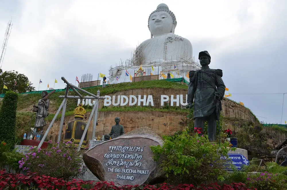 The hillside BIG BUDDHA PHUKET sign with a bronze King Rama V statue, monk statues and the site marker stone in front