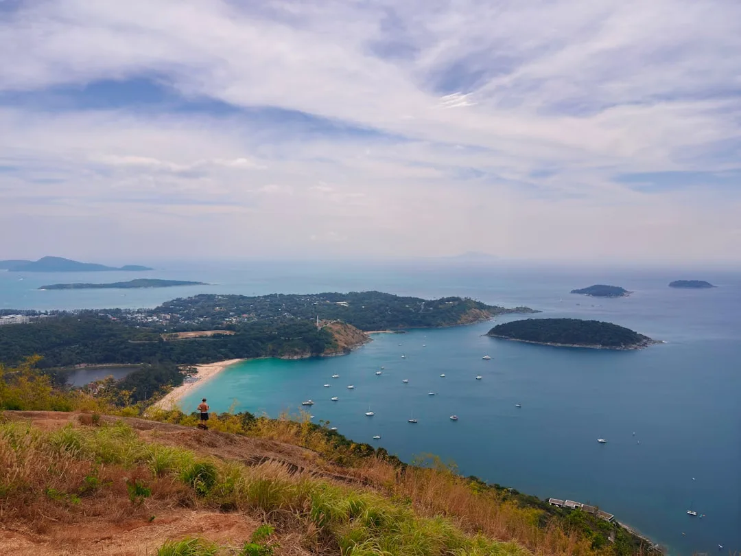 Karon Beach Phuket: fine white sand stretches along the bay with palm trees and the Andaman Sea at sunset