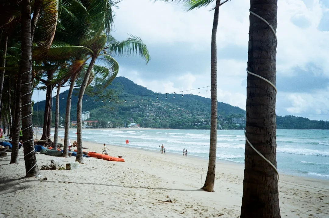 Patong Beach Phuket at sunrise: 2.85 km of white sand with turquoise Andaman Sea and jungle hills behind
